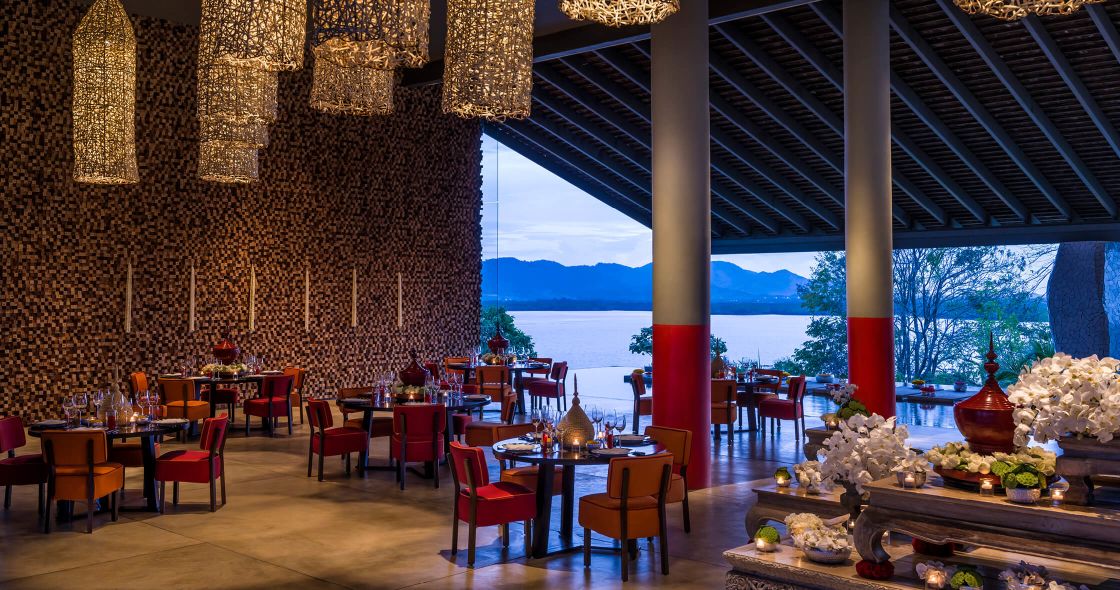 A Room With Tables And Chairs And A View Of The Water