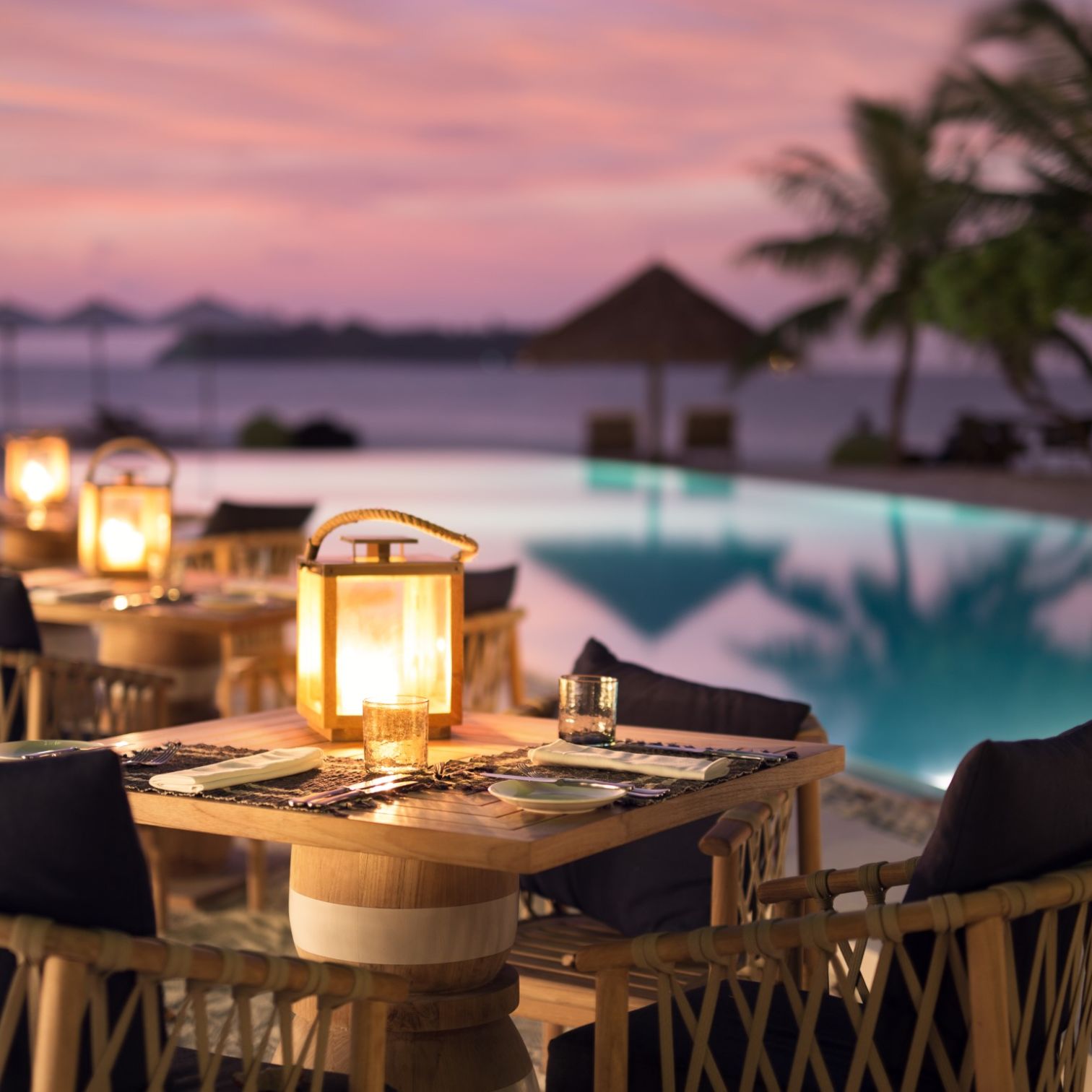 A Table With A Glass Of Wine On It By A Pool