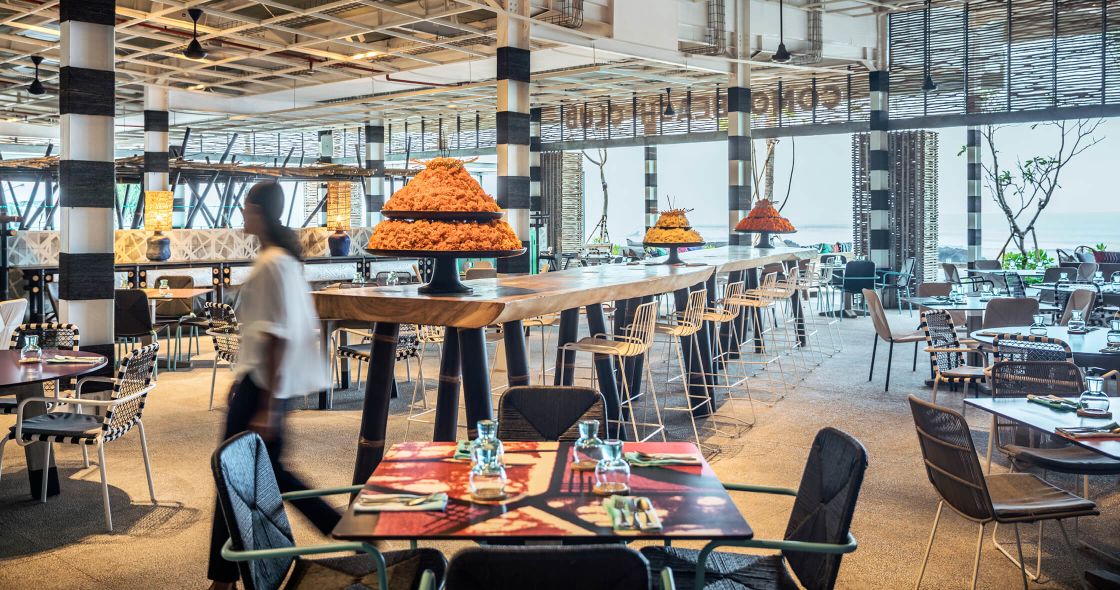 A Person Standing In A Large Room With Tables And Chairs