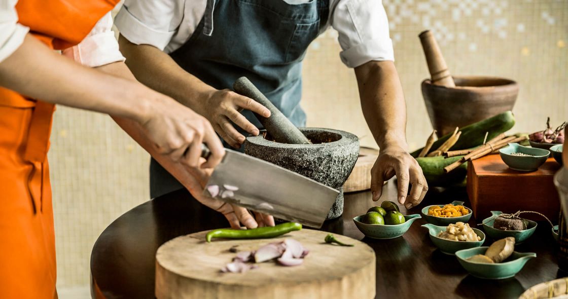 A Couple Of People Cutting Up Food