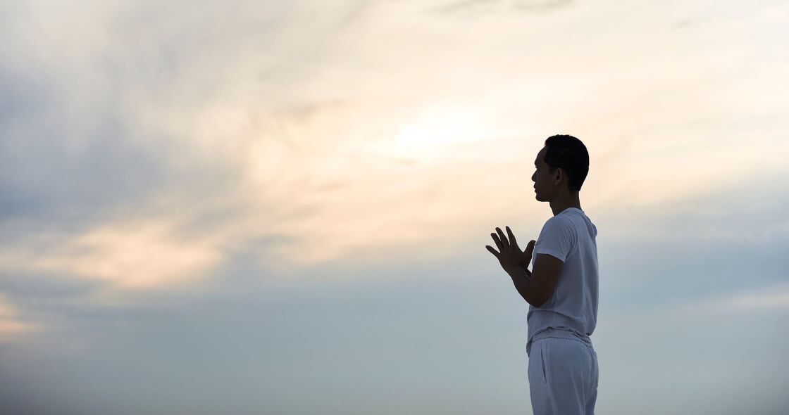 A Man Standing In Front Of A Cloudy Sky