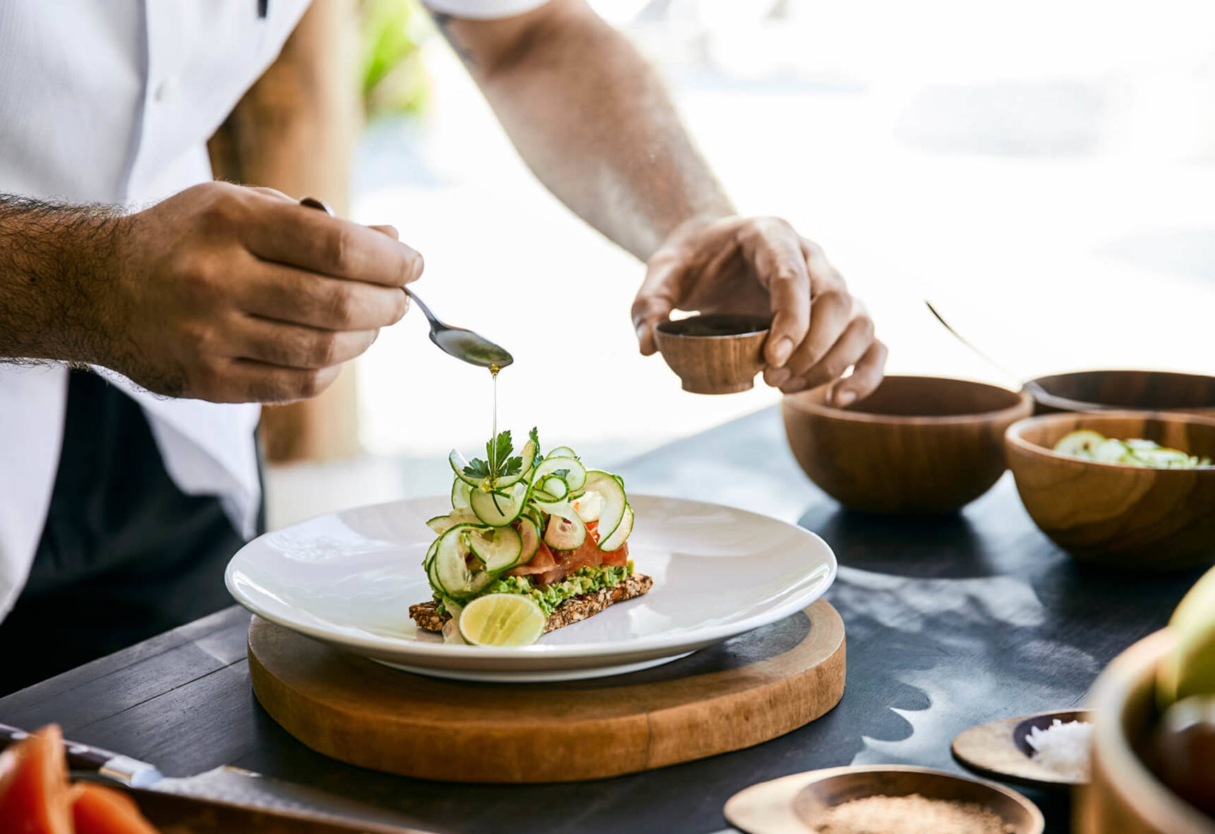 A Person Pouring A Liquid Into A Bowl Of Food