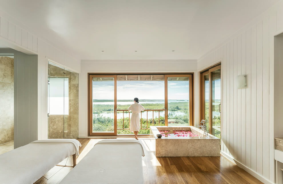 A Person In A White Dress In A Room With A Large Window