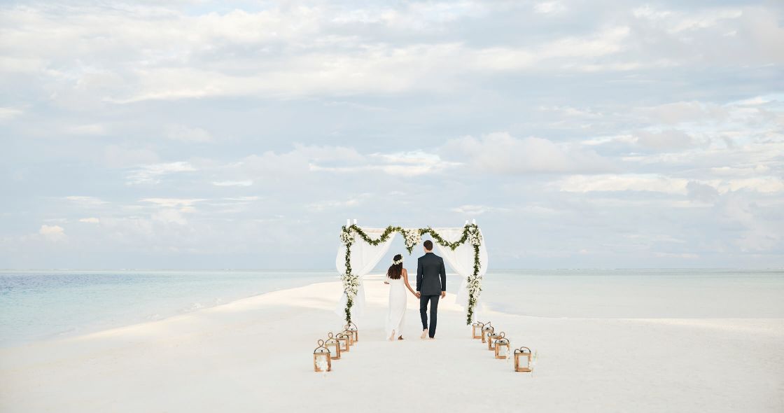 A Man And Woman Walking On A Beach