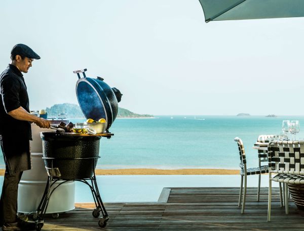 A Person Grilling On A Pier