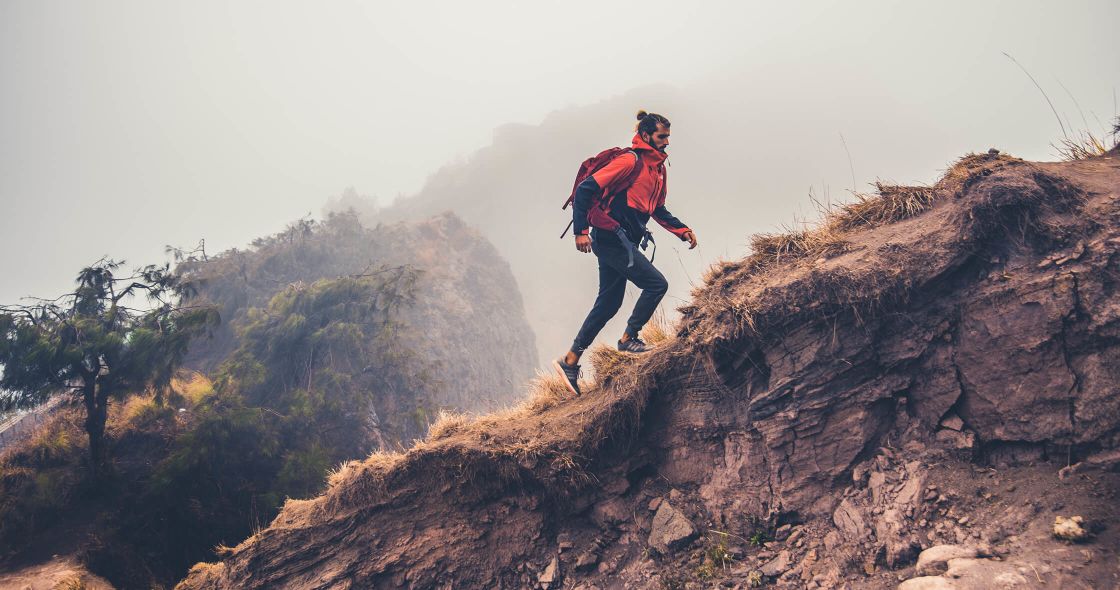 A Man Walking On A Rocky Hill