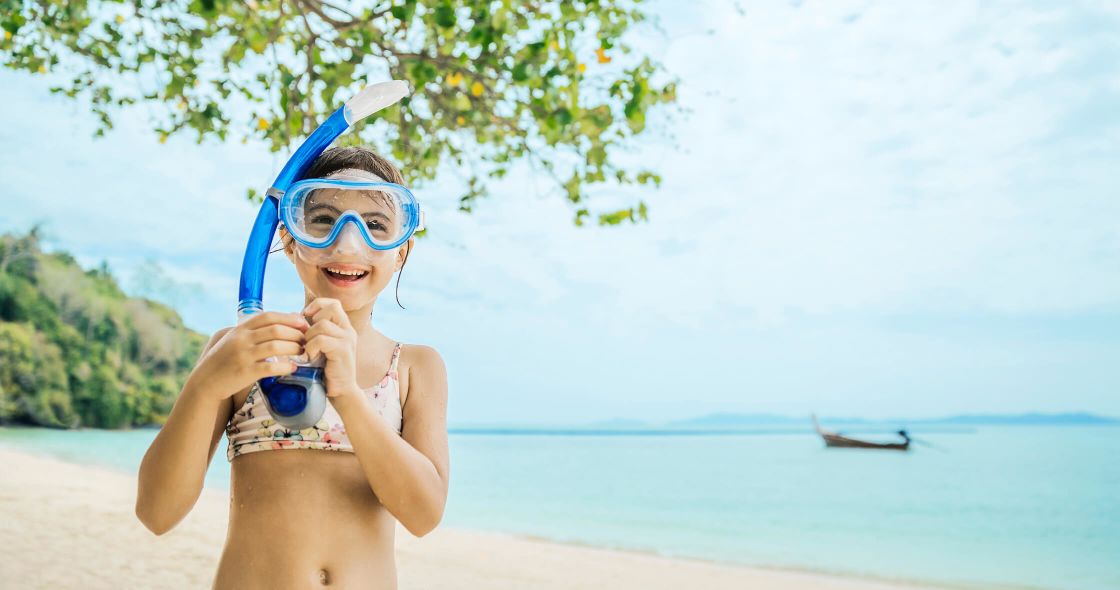 A Person Wearing Goggles And A Hat Holding A Camera