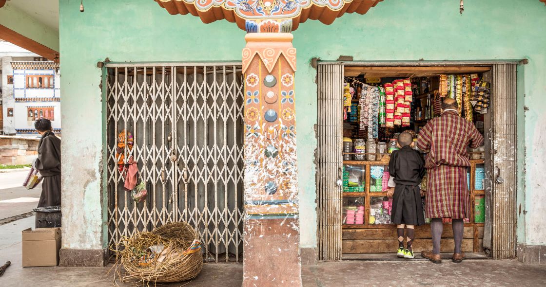 A Group Of People Standing Outside A Store