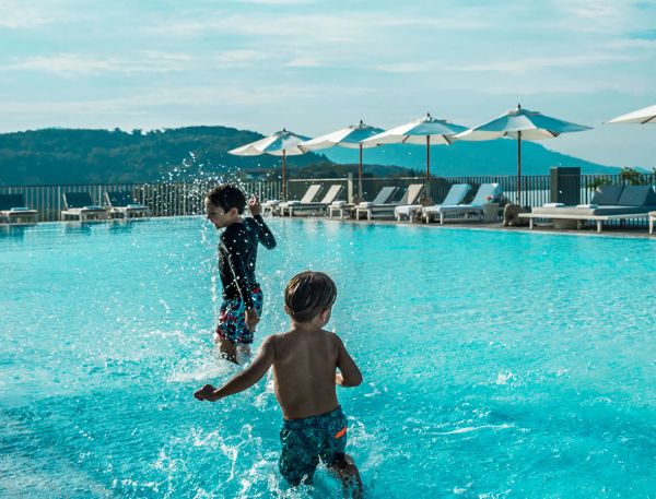 A Group Of Children Playing In A Pool