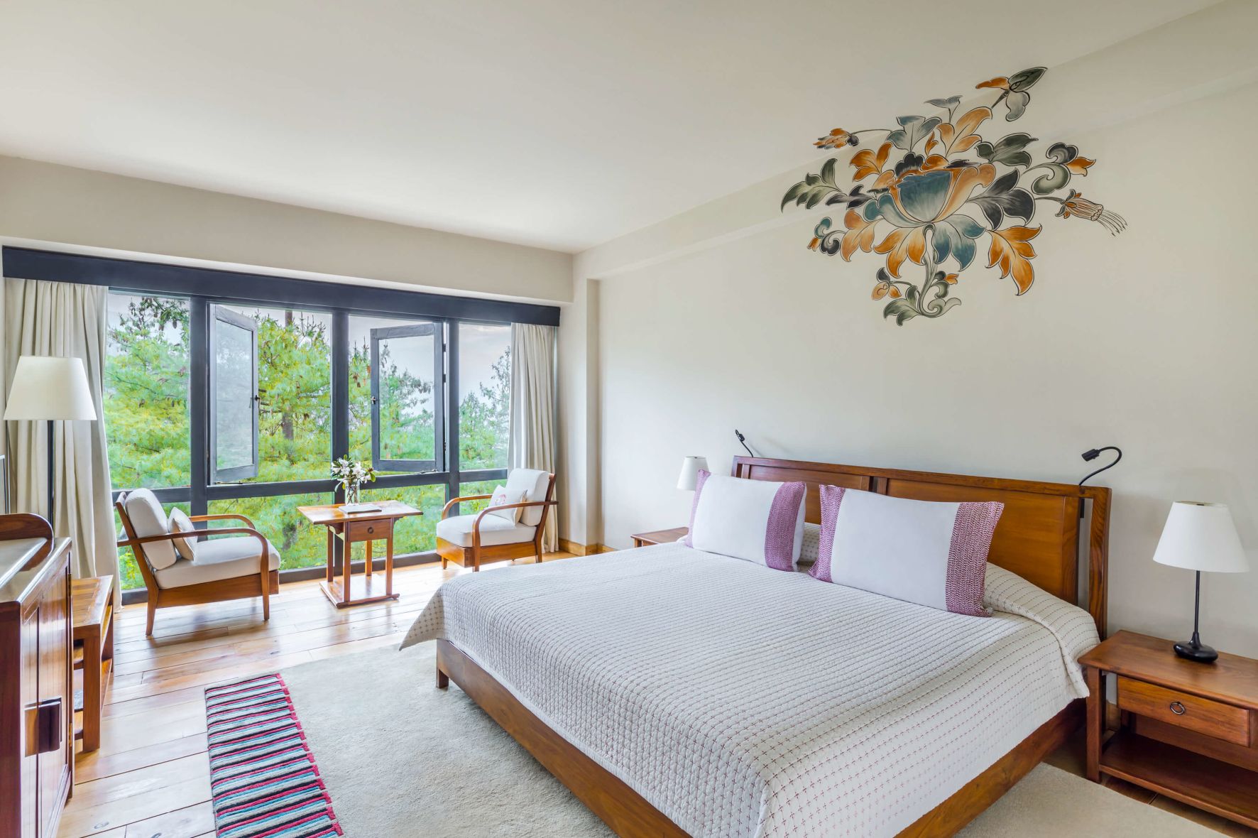 A Bedroom With A Bed And Chairs