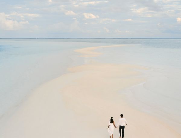 A Couple Walking On A Beach
