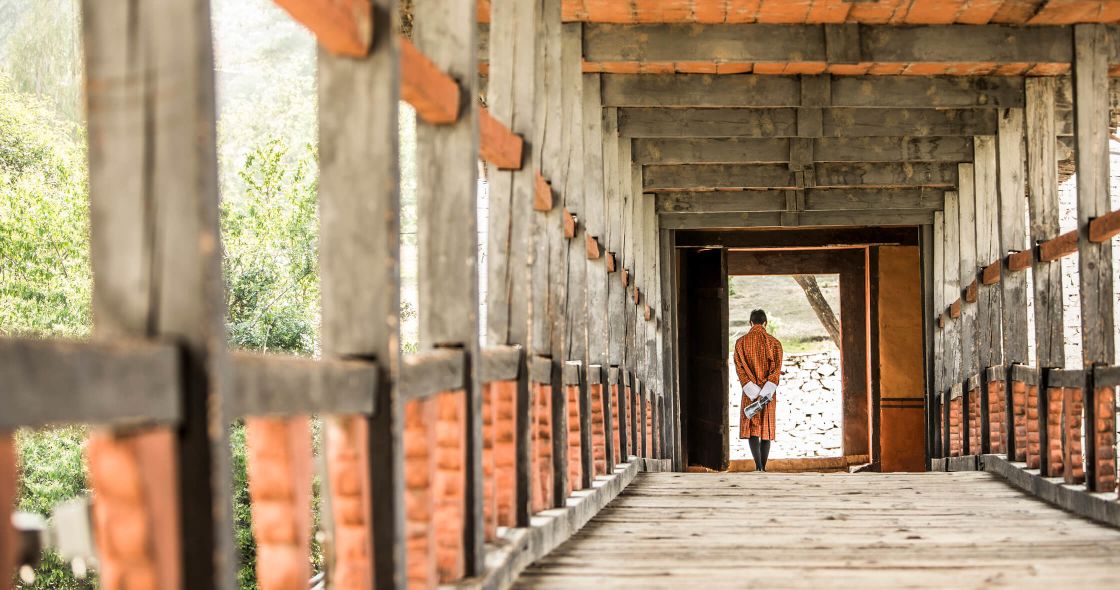 A Person Walking Out Of A Wooden Building