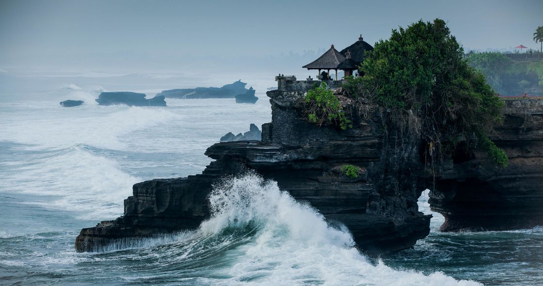 A Small Island With A Tree On It Surrounded By Water