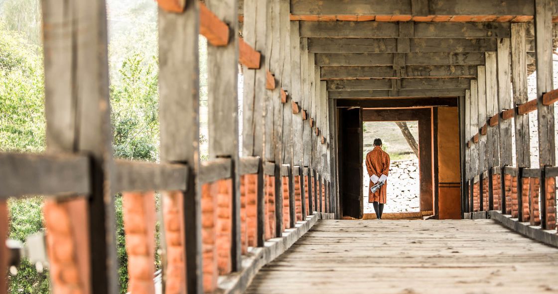A Person Walking Out Of A Wooden Building