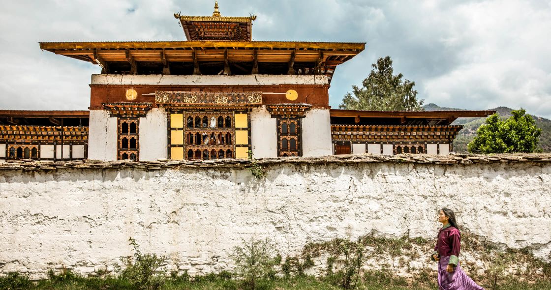 A Person Standing In Front Of A Building With A Large Gold Roof